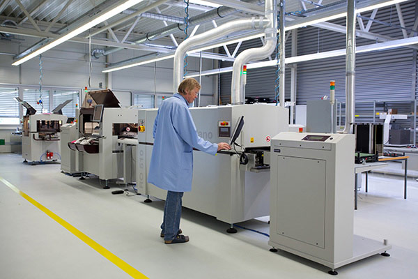 Modern SMT placement machine with conveyor and technician in clean workshop